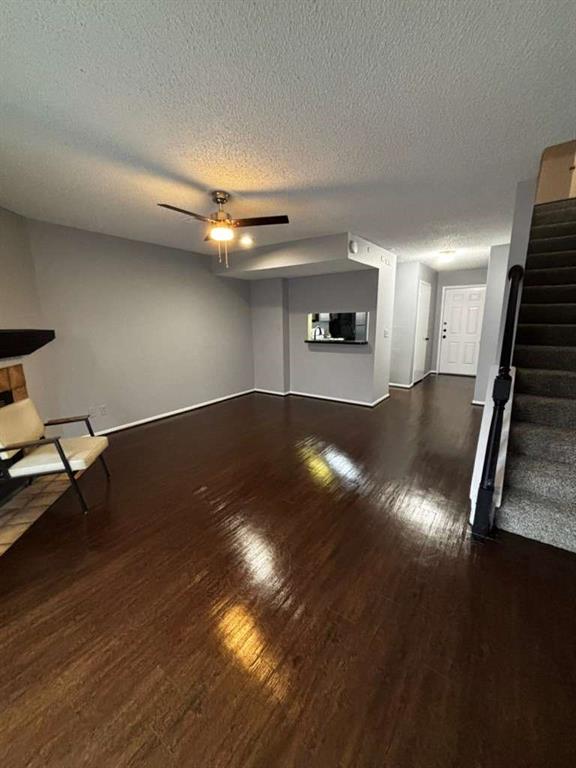 724 West Collins Street Denton, TX 76201 - Photo 7 of 12 a view of an empty room with wooden floor a ceiling fan and a window