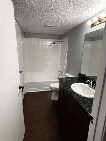 a bathroom with a granite countertop sink toilet and shower
