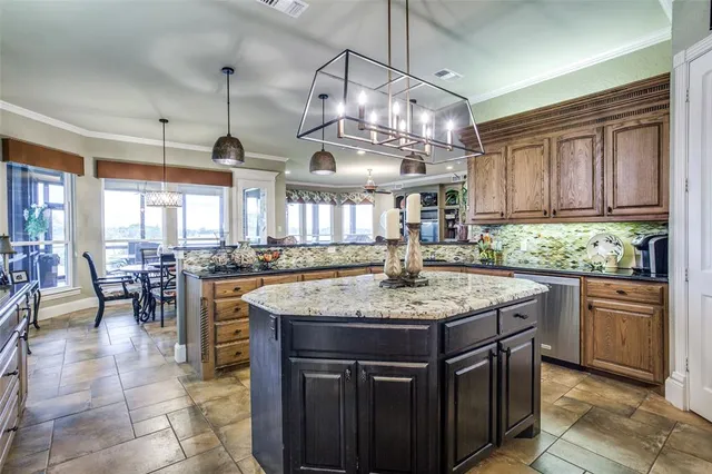 a kitchen with stainless steel appliances granite countertop a sink a stove and a wooden cabinets