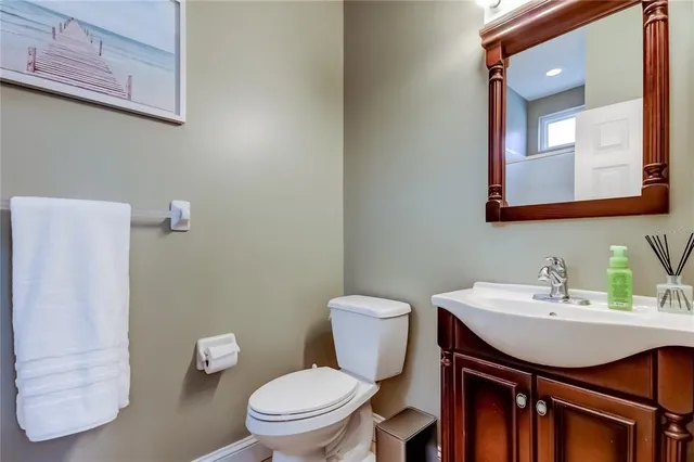 a bathroom with a toilet a sink and mirror
