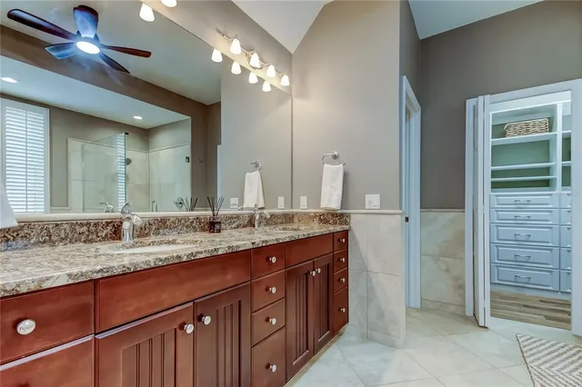 a bathroom with a granite countertop sink two mirror and a