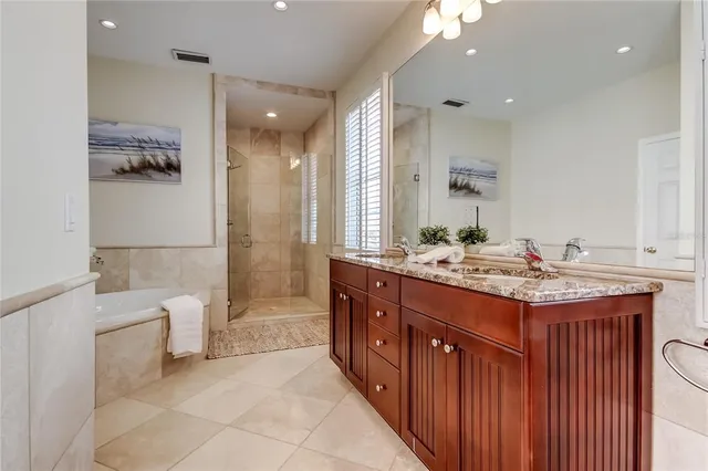 a bathroom with a double vanity sink a mirror and a bathtub