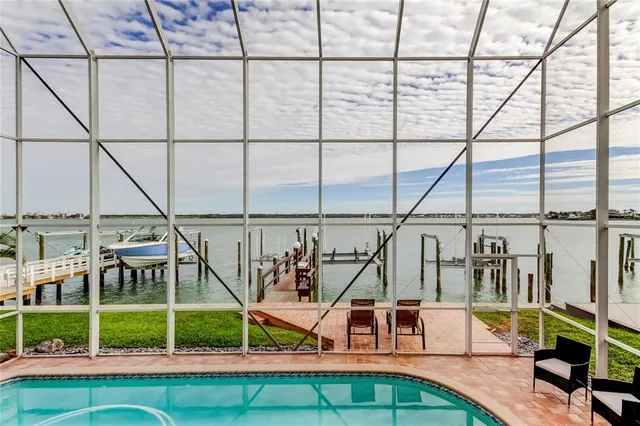 a view of a swimming pool with a chairs and couches in the background