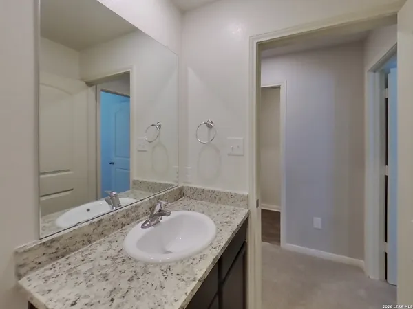 a bathroom with a granite countertop sink and a mirror