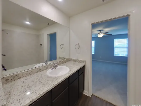 a bathroom with a granite countertop sink and a mirror