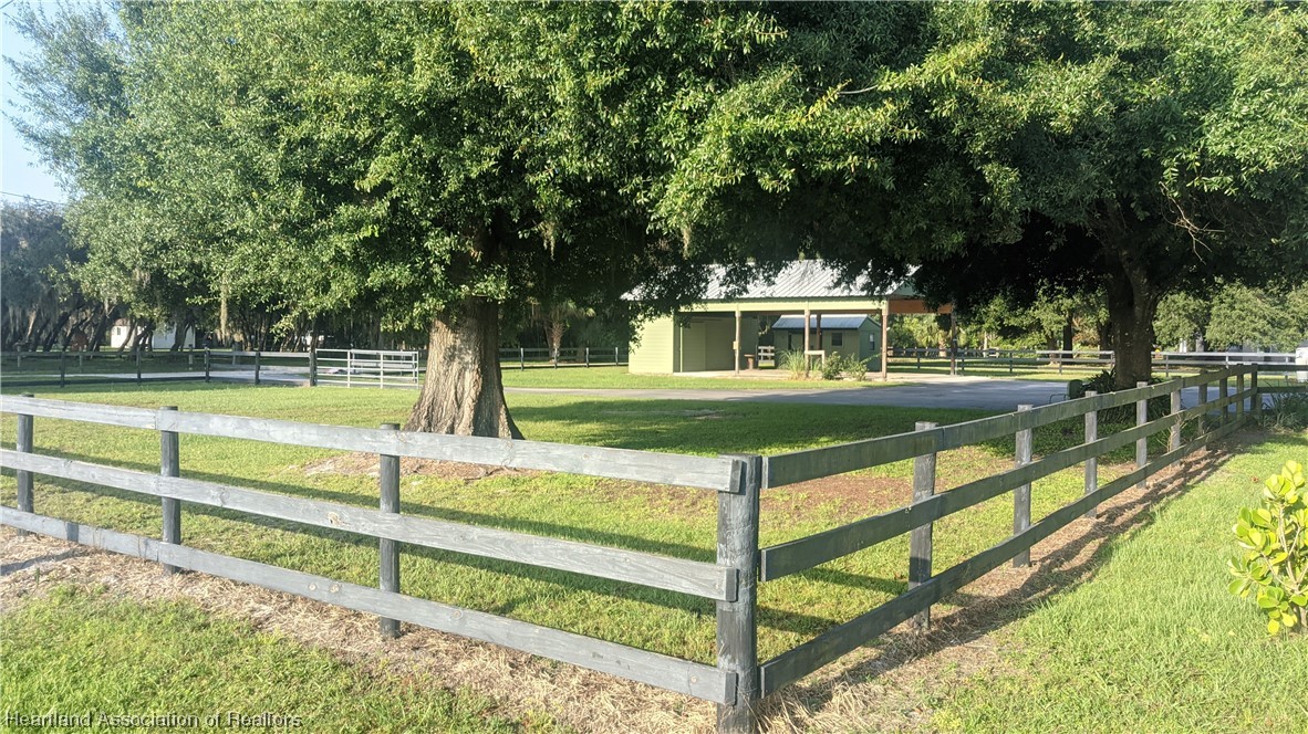 617 Bost Road Wauchula, FL 33873 - Photo 8 of 38 a view of swimming pool with lawn chairs and large trees