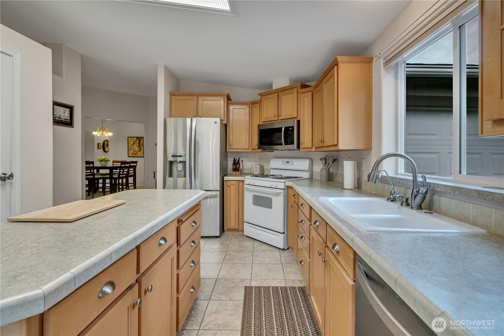 24319 68th Street East, Unit 84 Buckley, WA 98321 - Photo 13 of 40 a kitchen with kitchen island granite countertop a sink stove refrigerator and cabinets
