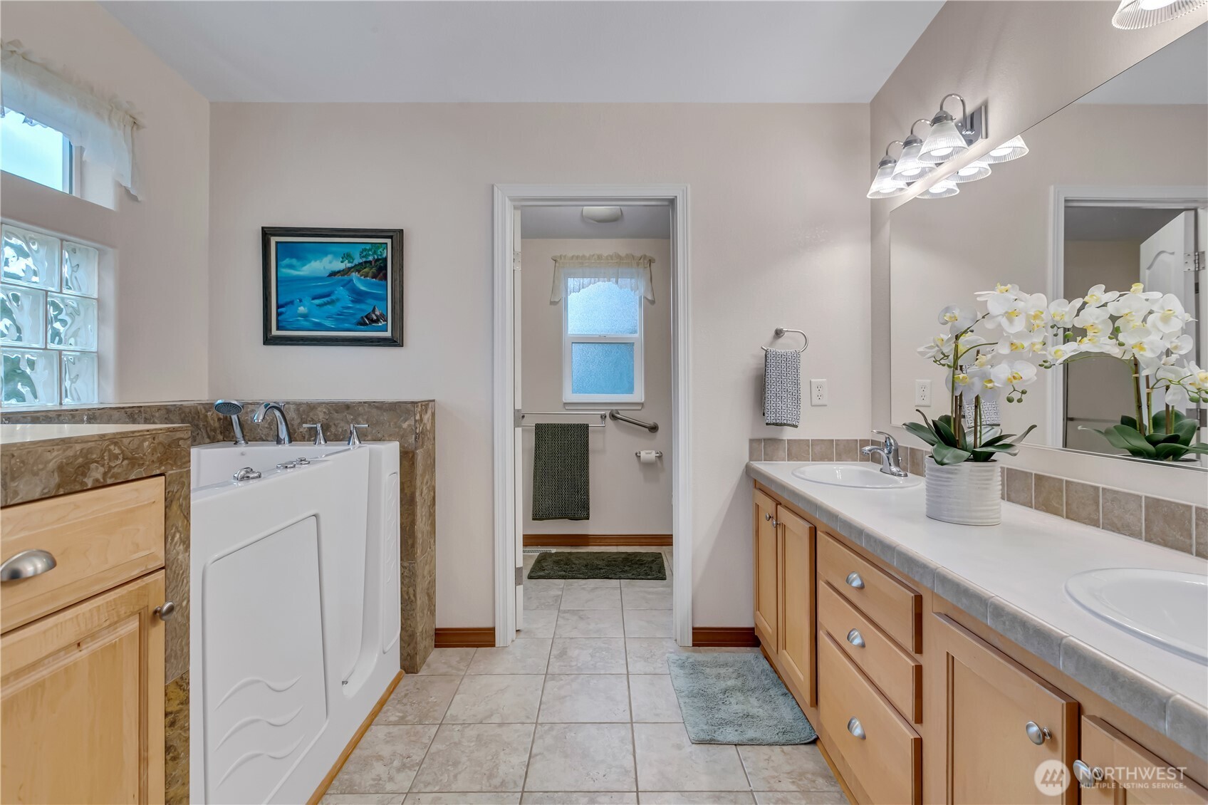24319 68th Street East, Unit 84 Buckley, WA 98321 - Photo 21 of 40 a spacious bathroom with a double vanity sink a mirror and a shower