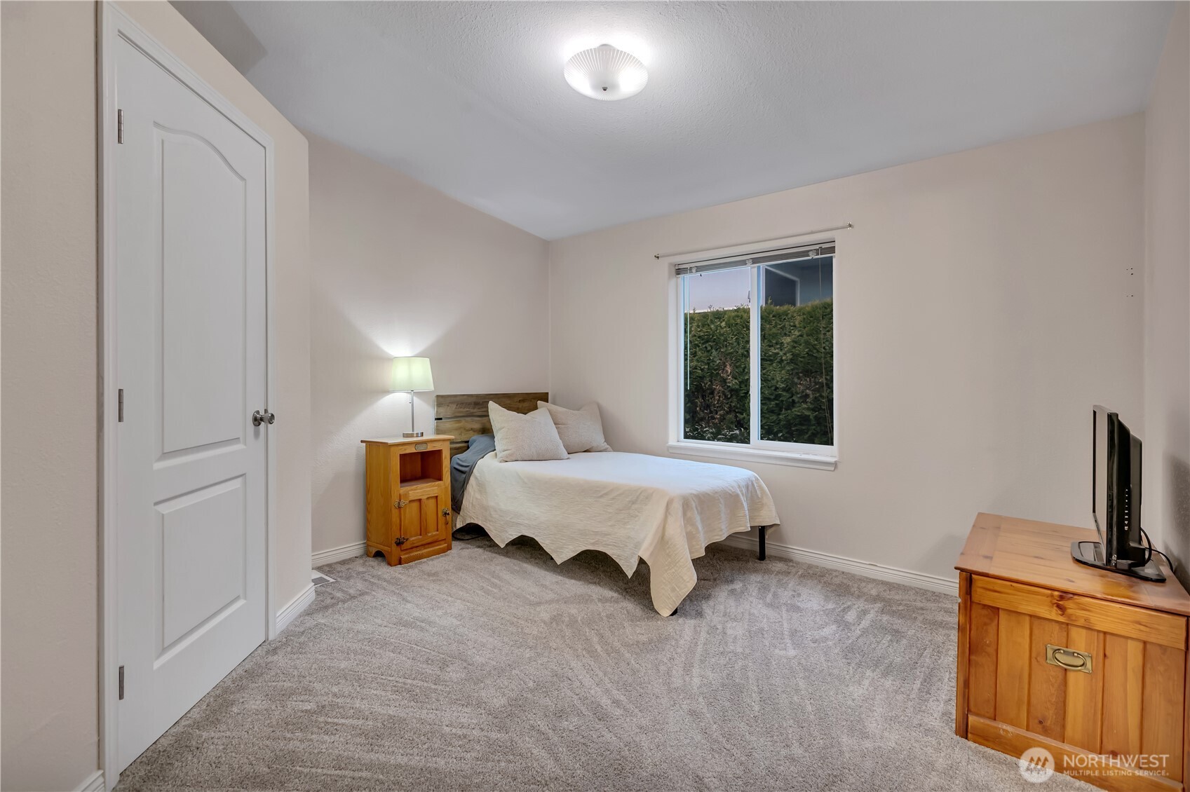 24319 68th Street East, Unit 84 Buckley, WA 98321 - Photo 25 of 40 a spacious bedroom with a bed and a flat tv screen on a dresser