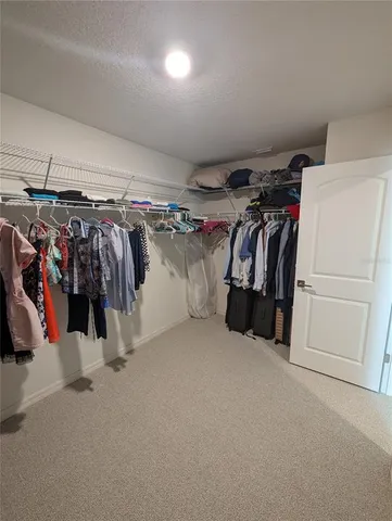a view of walk in closet with clothes