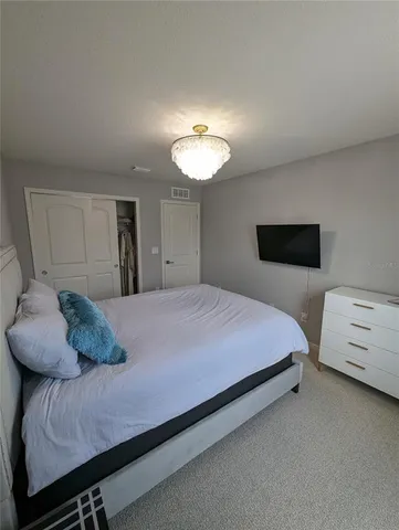 a bedroom with a bed and a chandelier