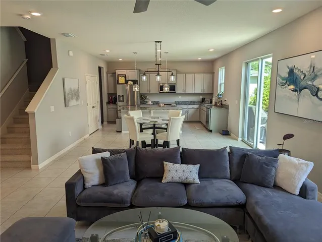 a living room with furniture kitchen and a chandelier