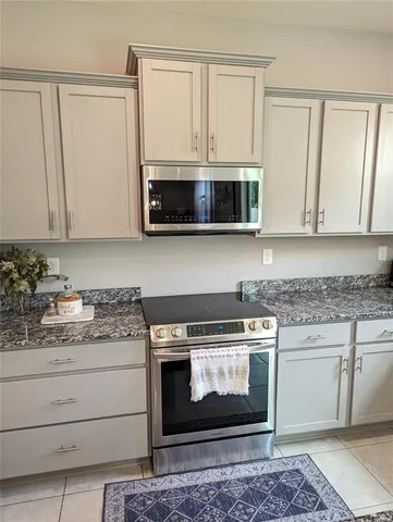 a kitchen with stainless steel appliances granite countertop a stove microwave and cabinets