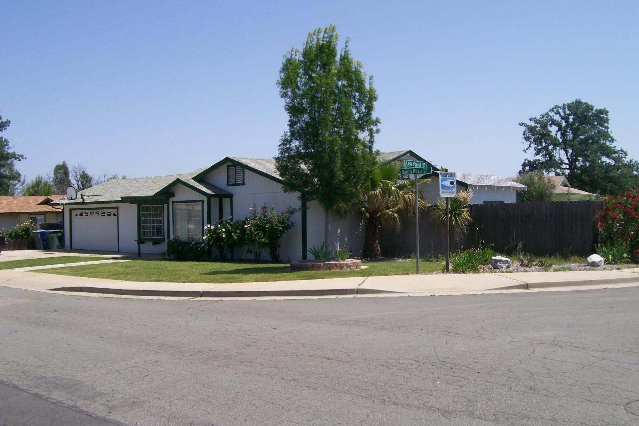 3607 Santa Rosa Way Redding, CA 96003 - Photo 2 of 10 a white house with a yard and a large trees with wooden fence