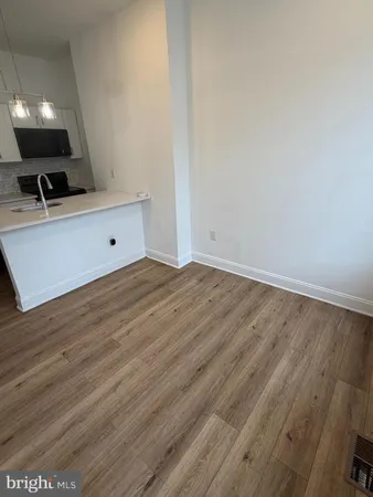 a view of room with wooden floor and fan