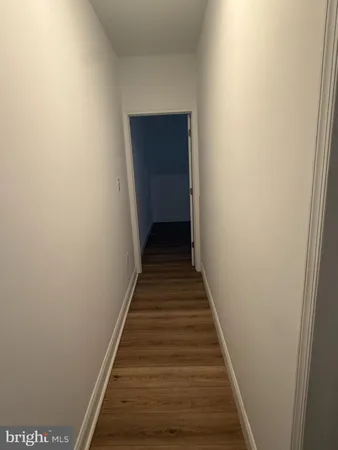 a view of a hallway with wooden floor and entryway