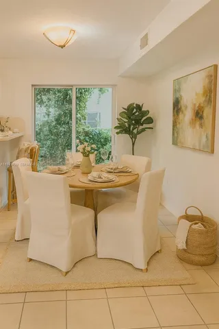 a dining room with furniture a window and a potted plant