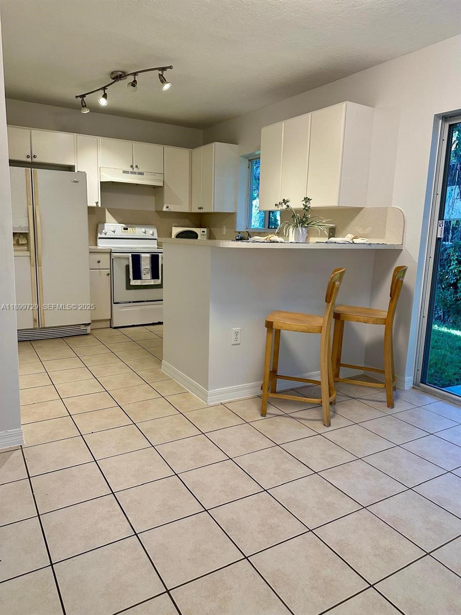 1270 Southeast 28th Court, Unit 101 Homestead, FL 33035 - Photo 19 of 27 a kitchen with stainless steel appliances a refrigerator sink and cabinets