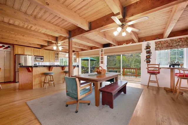 a kitchen with a stove a counter space a sink and living room view