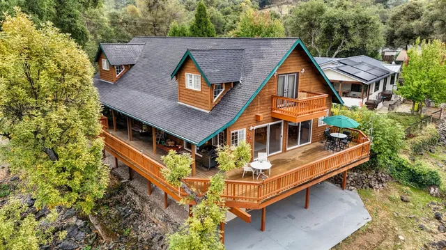 an aerial view of house with yard and mountain view in back