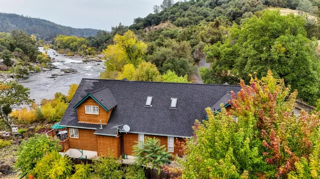 a view of house with a yard and balcony
