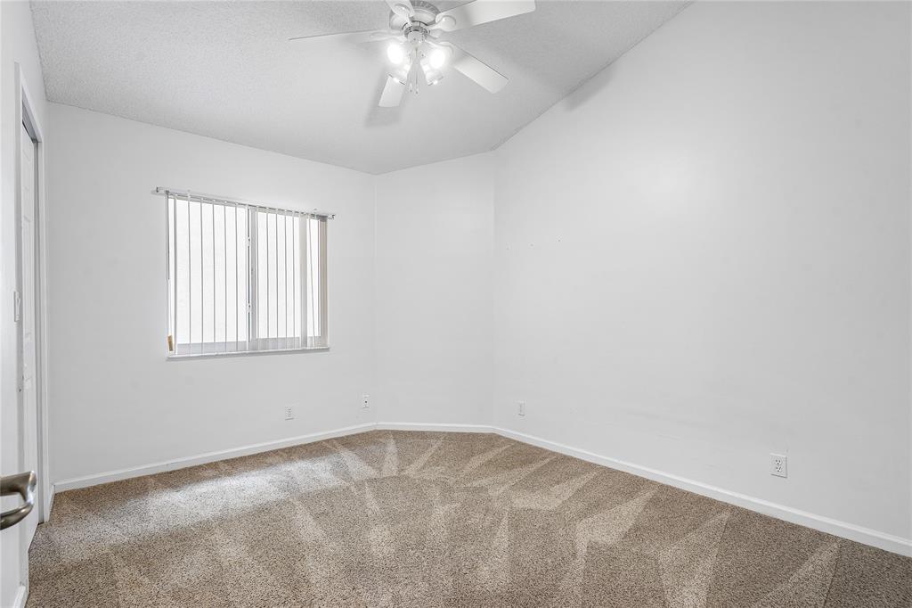 1443 Banyan Circle Pompano Beach, FL 33069 - Photo 19 of 36 an empty room with a chandelier fan