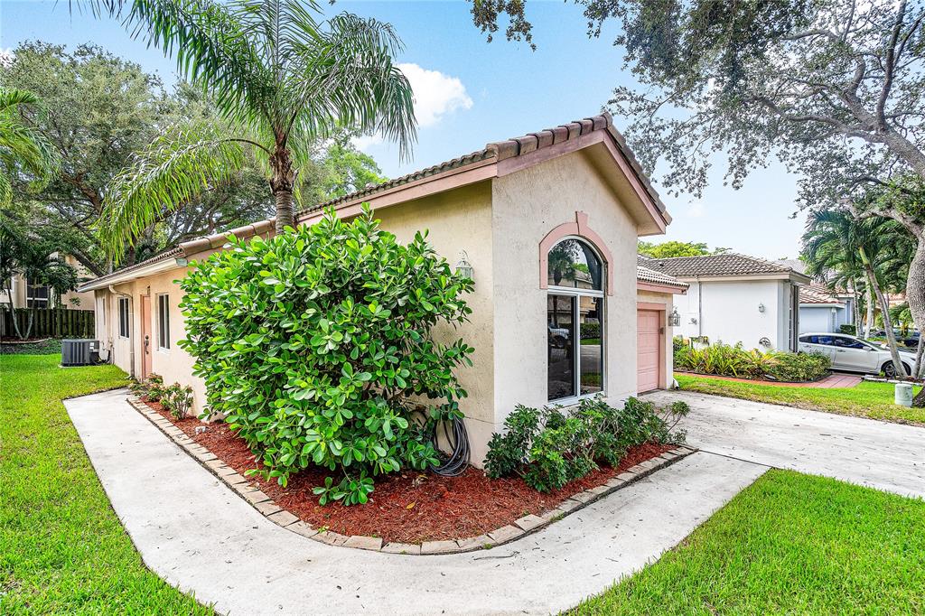 1443 Banyan Circle Pompano Beach, FL 33069 - Photo 2 of 36 a view of a house with a yard plants and a small yard