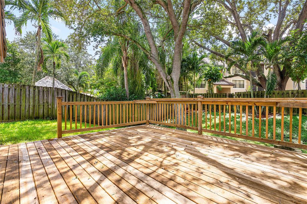1443 Banyan Circle Pompano Beach, FL 33069 - Photo 27 of 36 a view of backyard with wooden fence and trees