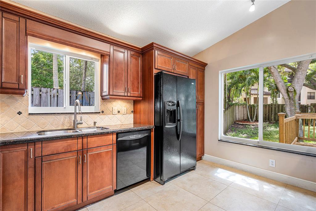 1443 Banyan Circle Pompano Beach, FL 33069 - Photo 7 of 36 a kitchen with stainless steel appliances granite countertop a refrigerator and a sink