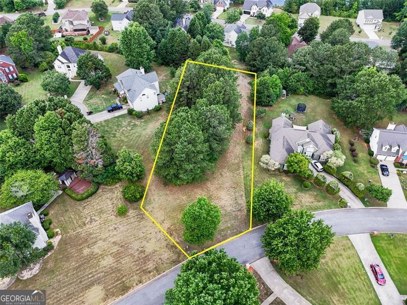 an aerial view of a house with a yard and black trees