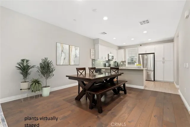 a living room with kitchen island furniture wooden floor and a potted plant