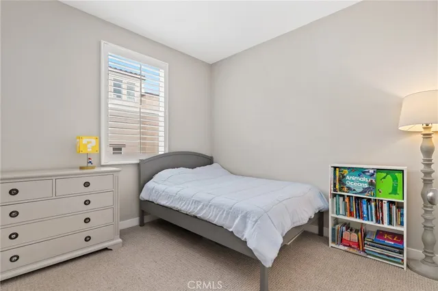 a bedroom with a bed a dresser and a window