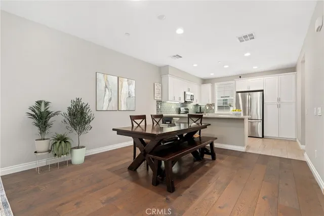a living room with kitchen island furniture wooden floor and a potted plant