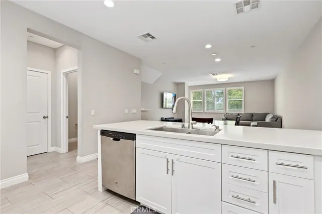 a kitchen with white cabinets and sink