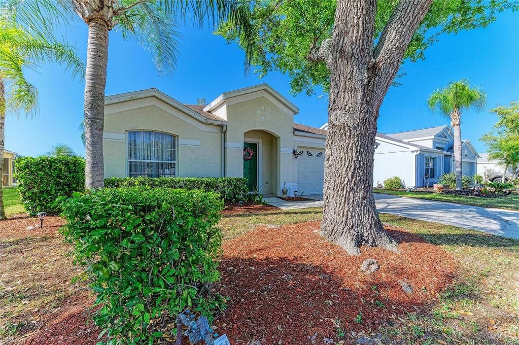 4642 Runabout Way Bradenton, FL 34203 - Photo 3 of 66 a front view of a house with a yard and a large tree