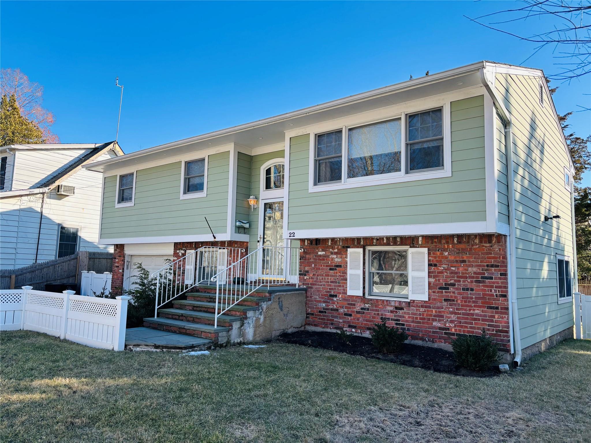 Raised ranch featuring a garage and a front yard