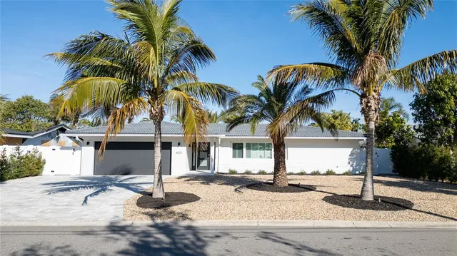 a front view of house with yard and palm tree