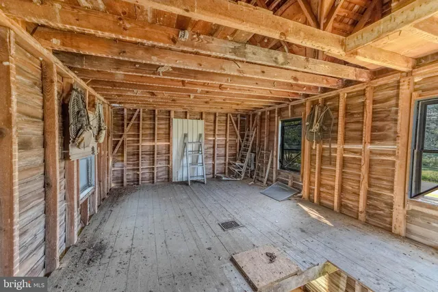 a view of an empty room with wooden floor and a sink