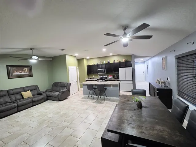 a large kitchen with stainless steel appliances a large counter top and a stove