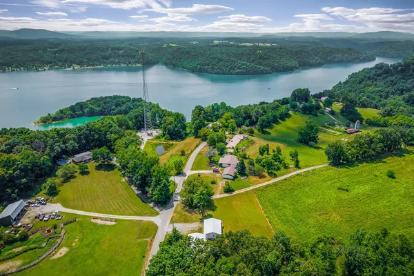 an aerial view of a residential houses with outdoor space and a lake view