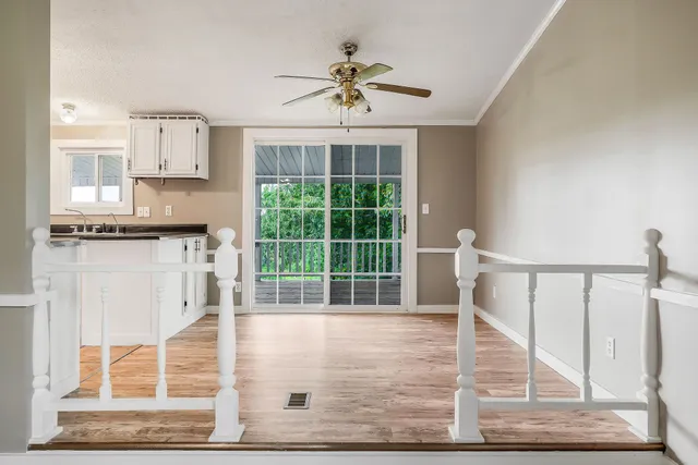 a kitchen with stainless steel appliances kitchen island granite countertop a refrigerator a stove a sink dishwasher and white cabinets with wooden floor