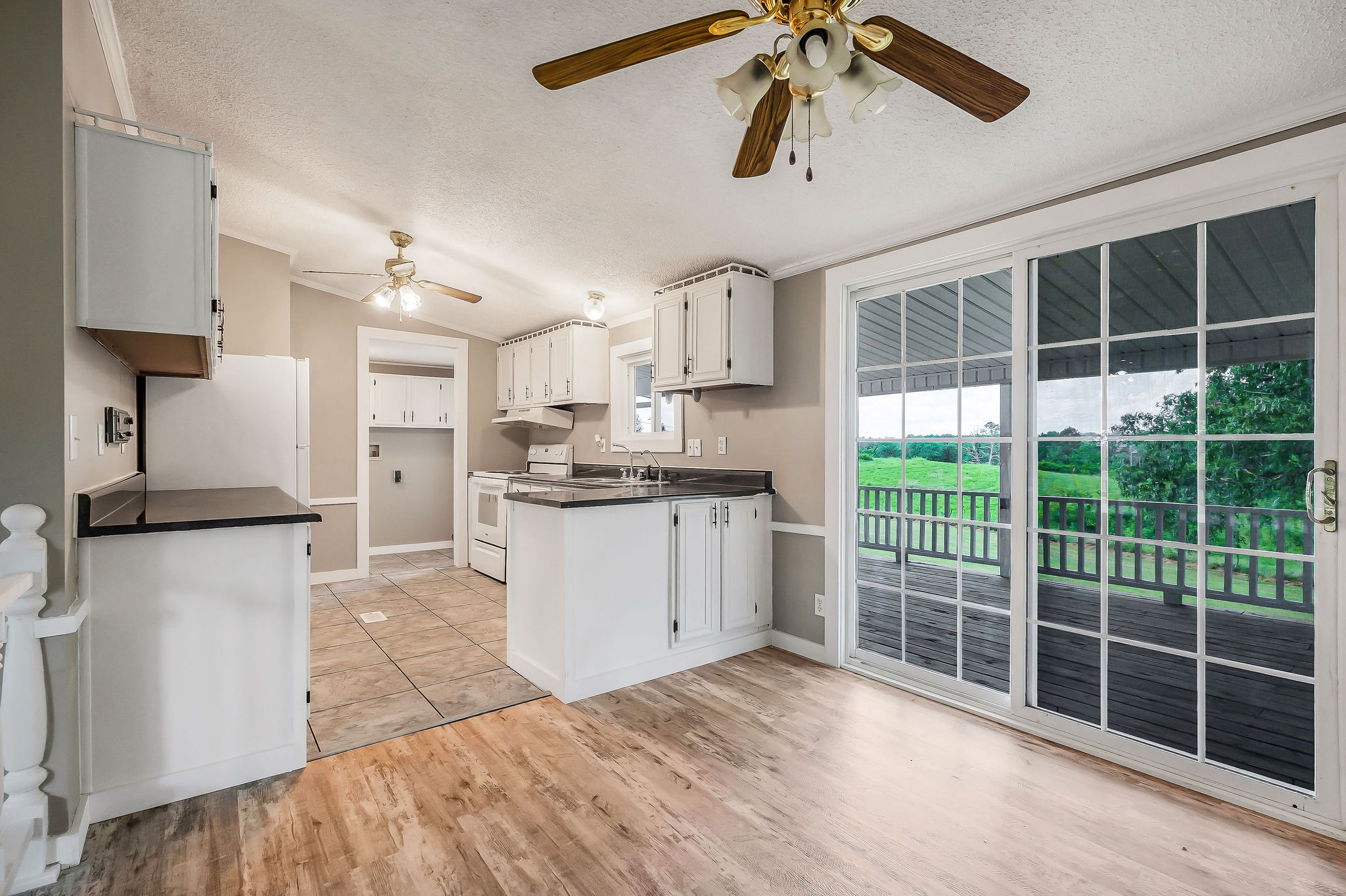 572 Lakeside Road Byrdstown, TN 38549 - Photo 18 of 44 a kitchen with stainless steel appliances kitchen island granite countertop a refrigerator a stove a sink dishwasher and white cabinets with wooden floor