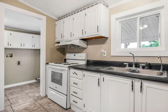 a kitchen with granite countertop a sink and cabinets