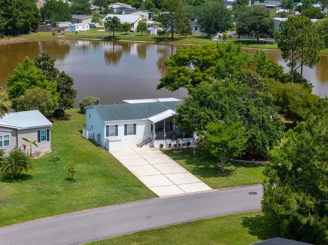 a view of a house with a yard and a pond