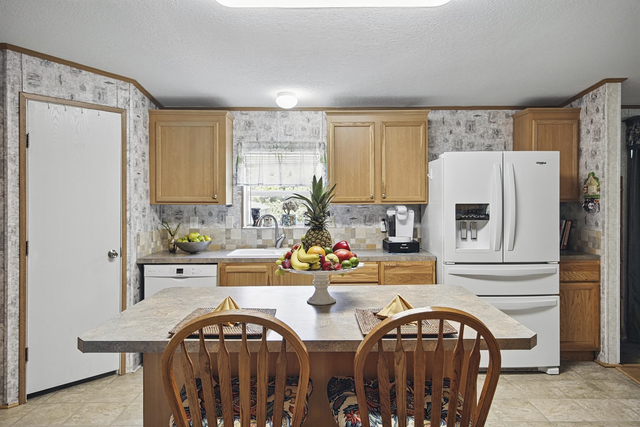2257 Whippoorwill Drive St. Augustine, FL 32084 - Photo 11 of 50 a view of kitchen with stainless steel appliances granite countertop a stove top oven a sink and a refrigerator