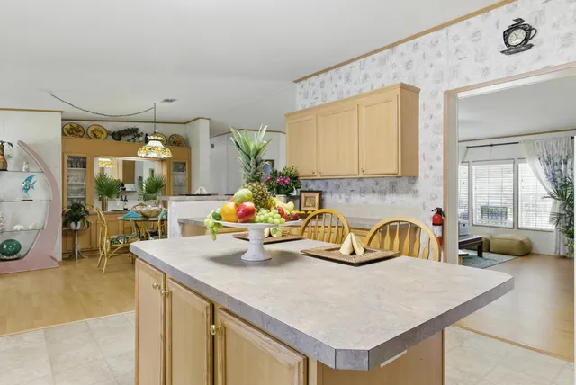 a kitchen with a sink a counter and a living room view