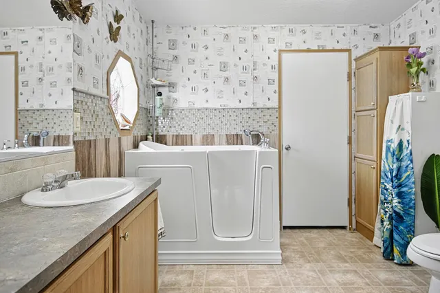 a bathroom with a sink a mirror a refrigerator and a mirror