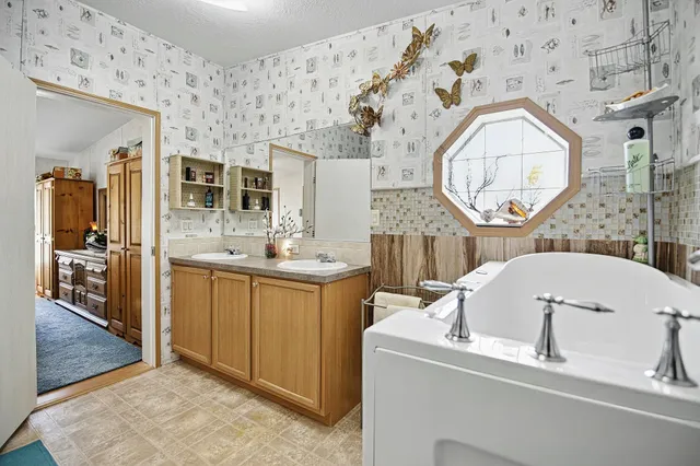 a bathroom with a tub sink and mirror