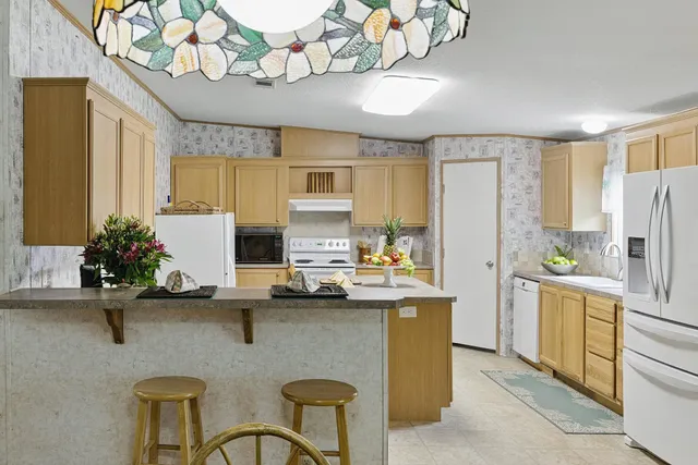 a kitchen with stainless steel appliances granite countertop a sink refrigerator stove and microwave