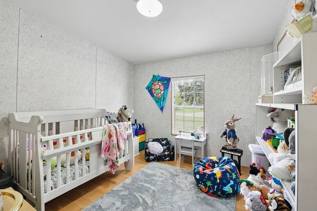 a bedroom with furniture a baby crib and a dresser